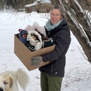 alt="Sherry Sinclair holding a box of donations for the stockings for seniors"