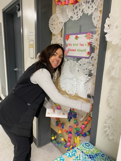 Amanda hanging Elf the Teacher door hangers at the school