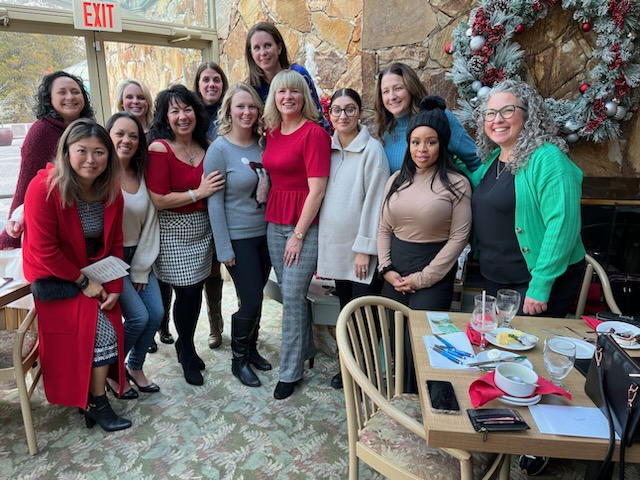 alt="Group of TPTM team members standing at a restaurant"